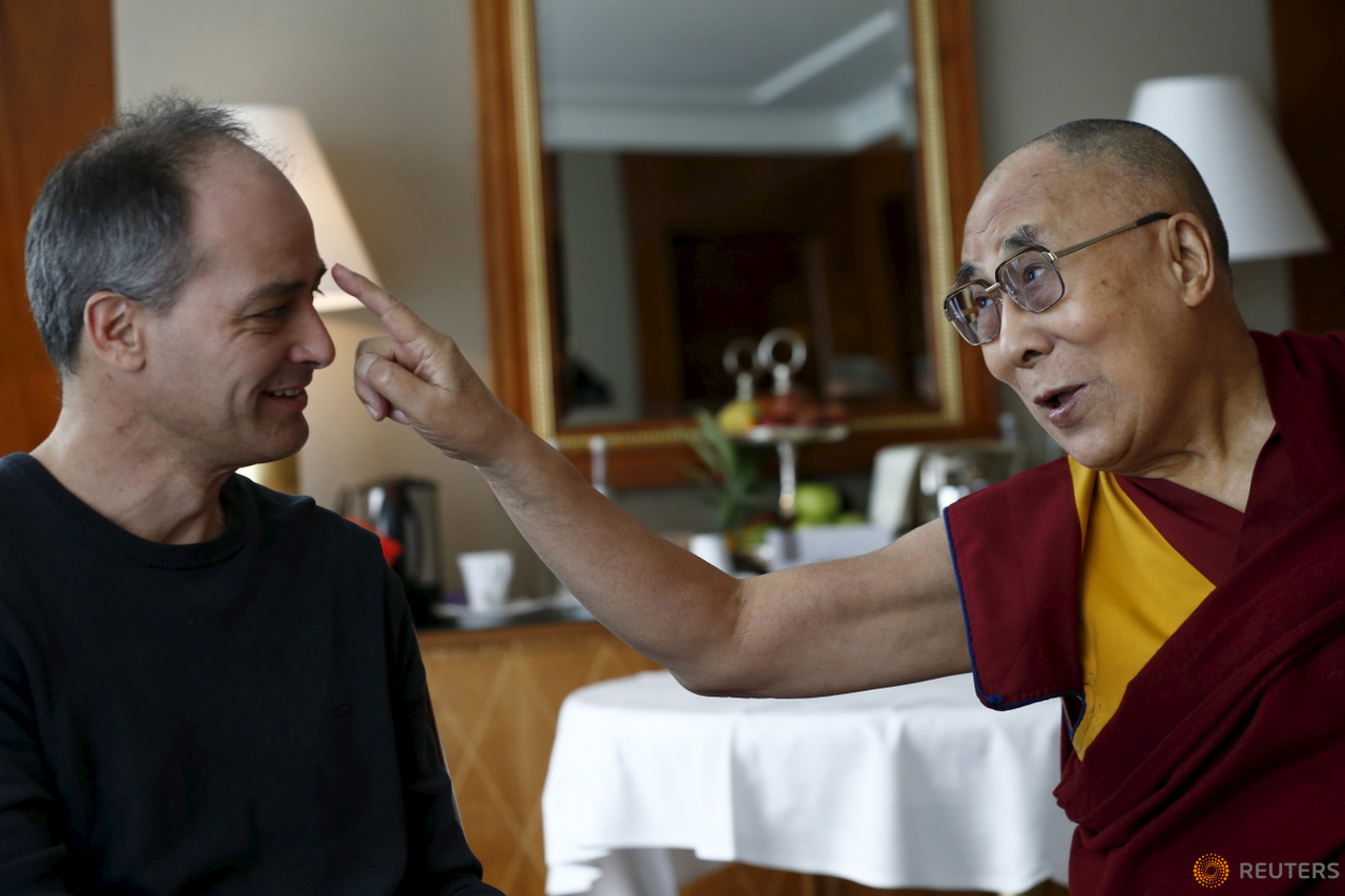 Tibetan spiritual leader the Dalai Lama jokes with Swiss journalist Frederic Koller of Le Temps/L'Hebod about his grey hair in Geneva, Switzerland March 11, 2016.  