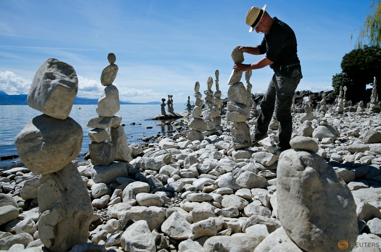 Swiss land art artist Daniel Dunkel builds a cairn on the shore of Lake Leman in Lutry, near Lausanne, Switzerland, April 14, 2016. 