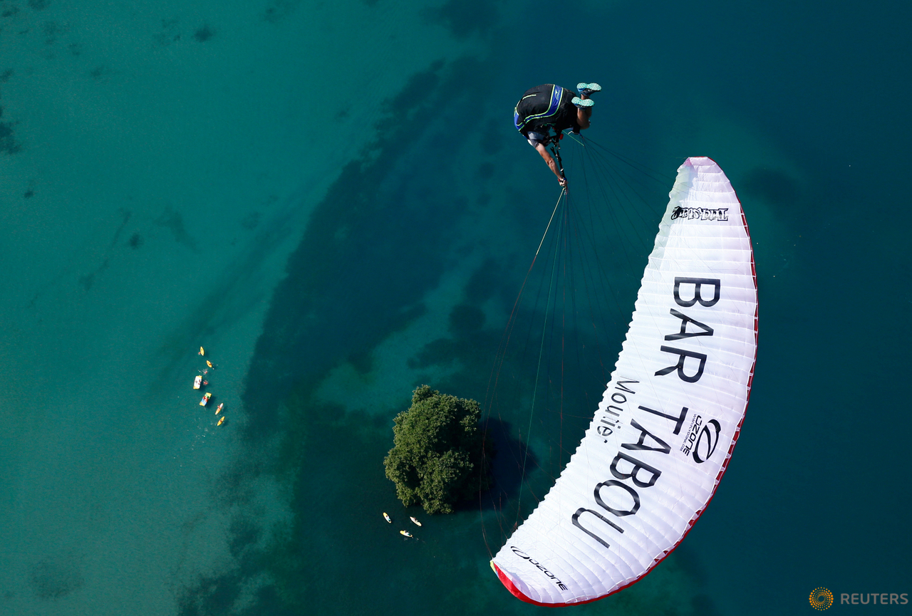 Morane Montavon, pilot of the Swiss Acro League, performs an infinity tumbling maneuver while paragliding above Lake Leman during a training session before the Acroshow competition in Villeneuve, Switzerland, August 17, 2016.  
