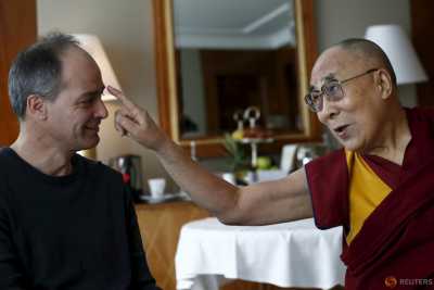 Tibetan spiritual leader the Dalai Lama jokes with Swiss journalist Frederic Koller of Le Temps/L'Hebod about his grey hair in Geneva, Switzerland March 11, 2016. Tibetan spiritual leader the Dalai Lama jokes with Swiss journalist Frederic Koller of Le Temps/L'Hebod about his grey hair in Geneva, Switzerland March 11, 2016.