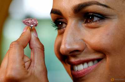 A model poses with the "Unique Pink", a 15.38 carats vivid pink diamond, at Sotheby's auction house in Geneva, Switzerland May 9, 2016. A model poses with the "Unique Pink", a 15.38 carats vivid pink diamond, at Sotheby's auction house in Geneva, Switzerland May 9, 2016.