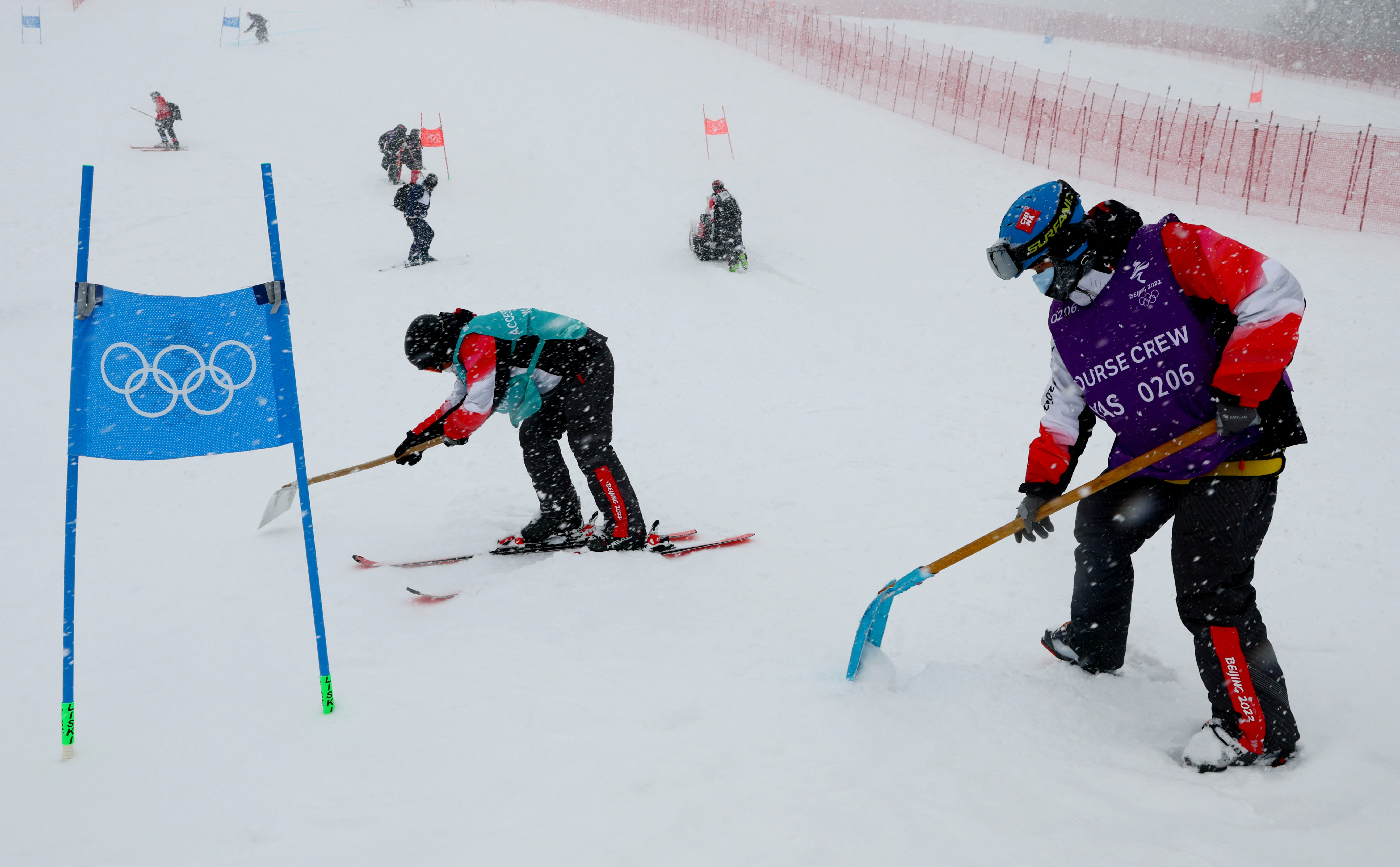 2022 Beijing Olympics - Alpine Skiing - Men's Giant Slalom Run 1 - National Alpine Skiing Centre, Yanqing district, Beijing, China - February 13, 2022. Workers clear snow ahead of the event. REUTERS/Denis Balibouse