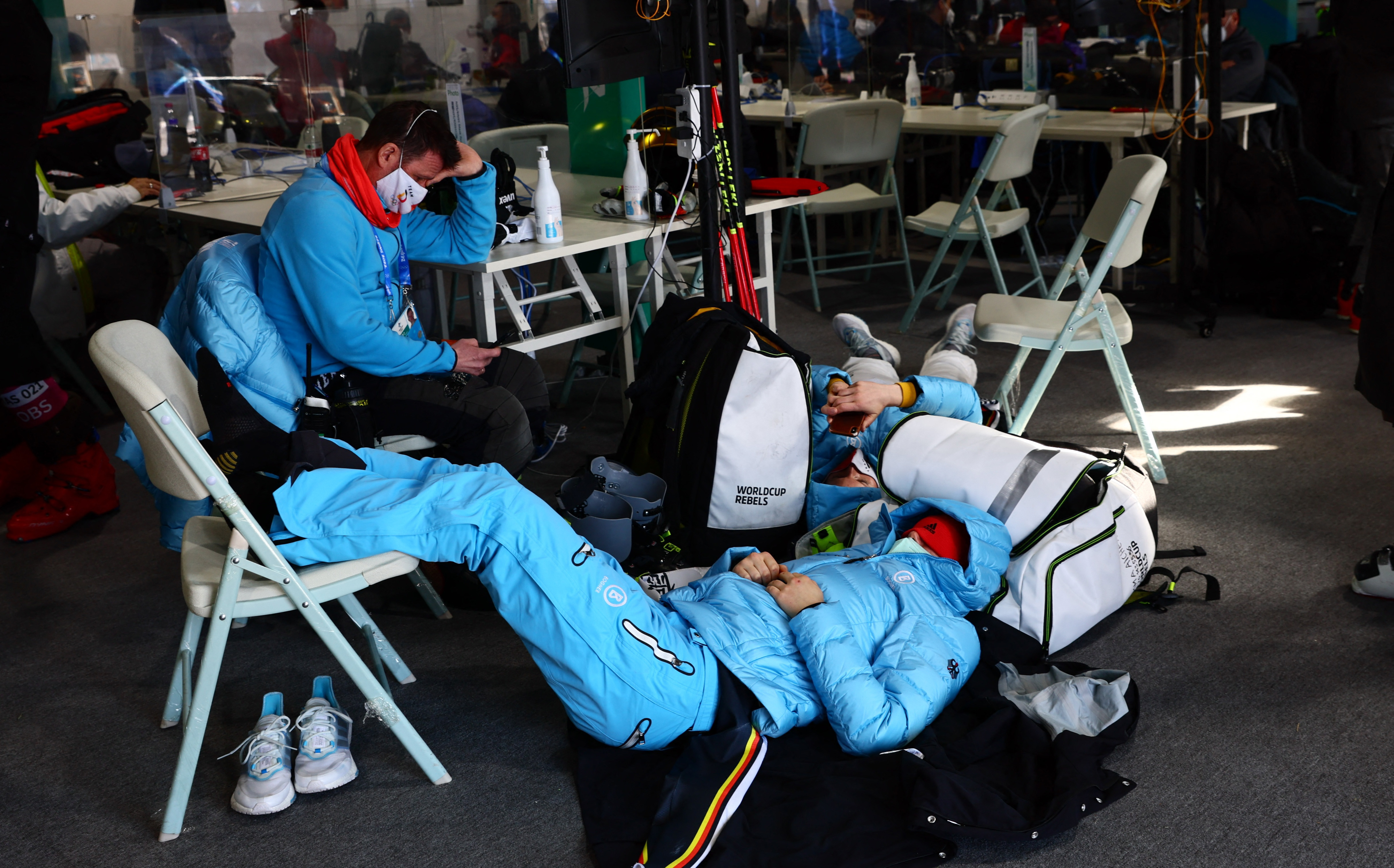 2022 Beijing Olympics - Alpine Skiing - Mixed Team Parallel 1/8 Finals - National Alpine Skiing Centre, Yanqing district, Beijing, China - February 19, 2022. Emma Aicher of Germany rests in the media facility with members of her team after organizers announced a delay to the start of the event. REUTERS/Denis Balibouse