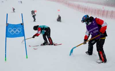 2022 Beijing Olympics - Alpine Skiing - Men's Giant Slalom Run 1 - National Alpine Skiing Centre, Yanqing district, Beijing, China - February 13, 2022. Workers clear snow ahead of the event. REUTERS/Denis Balibouse