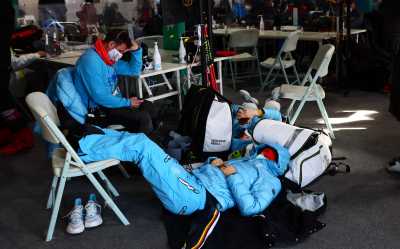 2022 Beijing Olympics - Alpine Skiing - Mixed Team Parallel 1/8 Finals - National Alpine Skiing Centre, Yanqing district, Beijing, China - February 19, 2022. Emma Aicher of Germany rests in the media facility with members of her team after organizers announced a delay to the start of the event. REUTERS/Denis Balibouse